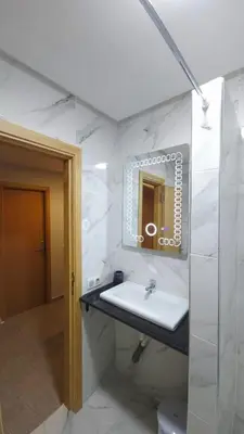 a white bathroom with a sink and a mirror at Charming Marrakech Duplex in Marrakech