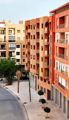 a tall building with a palm tree in front of it at Charming Marrakech Duplex in Marrakech