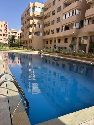a swimming pool in front of a building at Appartement à Marrakech 2 chambres avec piscine et parking Palmeraie Gates in Marrakech