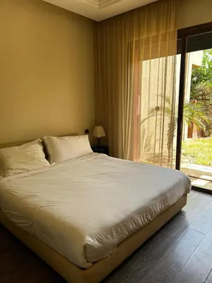 a bed in a bedroom with a large window at Vizir Center Apartment Marrakech A103 in Marrakech