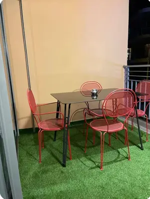 a table with red chairs and a table with grass at Charming Apartment Heart of Marrakech in Marrakech