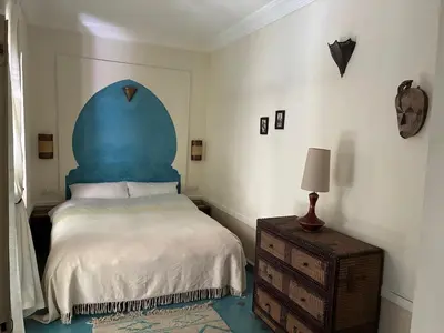 a bedroom with a bed with a blue headboard at RIAD VERT de Nina in Marrakech