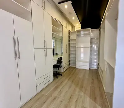 a walk in closet with white cabinets and a chair at 5-star luxury villa with private pool in Marrakech