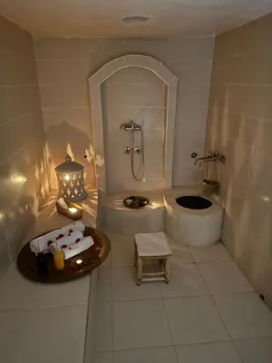 a white bathroom with a shower and a sink at Domaine JJ in Marrakech