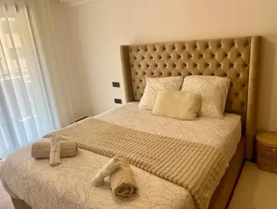 a bedroom with a large bed with a large headboard at Résidence palmeraie gates Marrakech in Marrakech