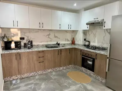 a kitchen with white cabinets and stainless steel appliances at Résidence palmeraie gates Marrakech in Marrakech