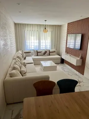a living room with a couch and a table at Résidence palmeraie gates Marrakech in Marrakech