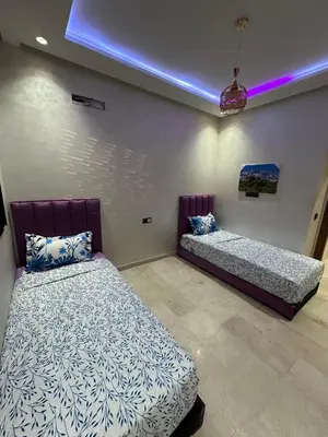 a bedroom with two beds and a blue light at Appartement a Marrakech centre in Marrakech