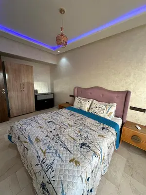 a bedroom with a large bed with a blue light at Appartement a Marrakech centre in Marrakech