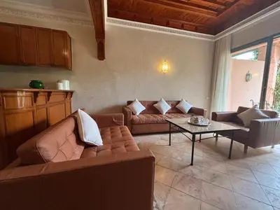 a living room with a couch and a table at Palmeraie village , lieu exceptionnel avec jardin et piscine in Marrakech