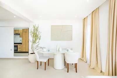 a white dining room with a white table and chairs at Magnifique appartement moderne 1 chambre proche de la gare de Gueliz in Marrakech