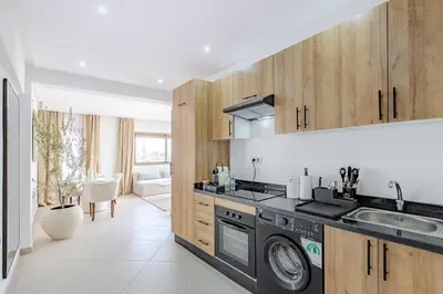a kitchen with a sink and a washing machine at Magnifique appartement moderne 1 chambre proche de la gare de Gueliz in Marrakech