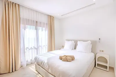 a bedroom with a white bed with two towels on it at Magnifique appartement moderne 1 chambre proche de la gare de Gueliz in Marrakech