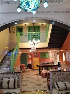 a living room with green cabinets and a staircase at Riad Yousra in Marrakech