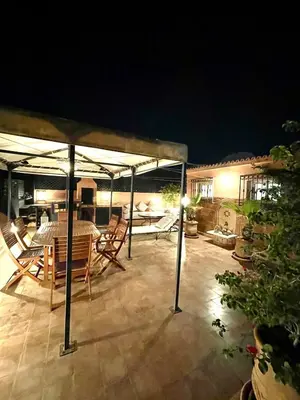 a patio at night with a table and chairs at Rooftop Sun Pool Chic Apartment Perfect Stay in Marrakech