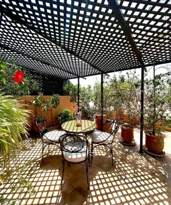 a patio with a table and chairs under a pergola at Rooftop Sun Pool Chic Apartment Perfect Stay in Marrakech