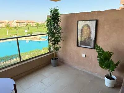 a balcony with plants and a view of a pool at Elegant Apartment in Prestigia Pool & Golf in Marrakech