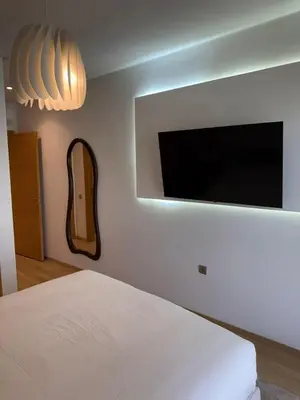 a bedroom with a bed and a flat screen tv at Elegant Apartment in Prestigia Pool & Golf in Marrakech