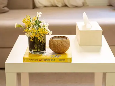 a white table with a vase of flowers on a book at NEW Cocon cosy au coeur de Marrakech in Marrakech