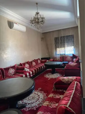 a living room with red couches and a chandelier at Villa Route de Casa in Marrakech