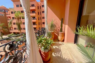a balcony with potted plants on a building at Menara Palms Marrakech in Marrakech