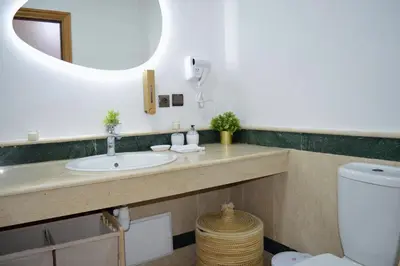a bathroom with a sink and a mirror and a toilet at Menara Palms Marrakech in Marrakech