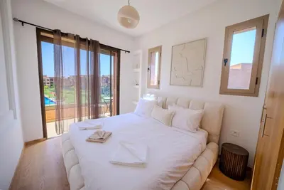 a bedroom with a large white bed with two napkins on it at Prestigia Apartment Secure Residence Pool in Marrakech