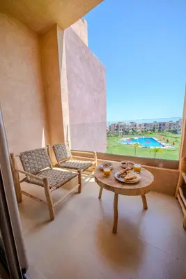 a room with a table and chairs and a window at Prestigia Apartment Secure Residence Pool in Marrakech