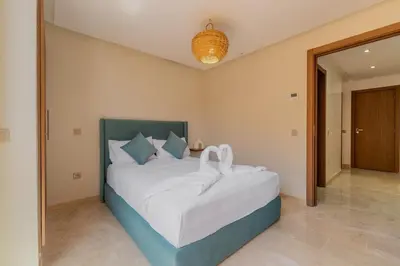 a bedroom with a bed with two swans on it at Rooftop piscine-new appartment - centre ville in Marrakech