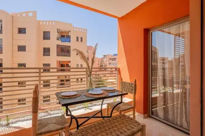 a balcony with a table and chairs and a window at Rooftop piscine-new appartment - centre ville in Marrakech