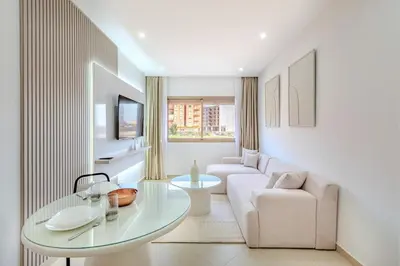 a white living room with a table and a couch at Appartement 1 chambre proche de la gare de Gueliz in Marrakech