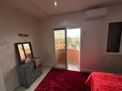 a bedroom with a bed and a large window at Achraf in Marrakech