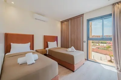 a bedroom with two beds and a large window at 2BR NEW Luxury apartment CityCenter in Marrakech