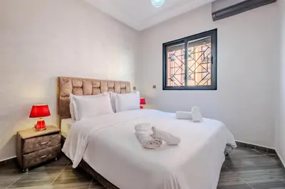a bedroom with a large white bed and a window at 5-min away to Marrakech Airport in Marrakech