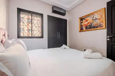 a bedroom with a white bed with towels on it at 5-min away to Marrakech Airport in Marrakech
