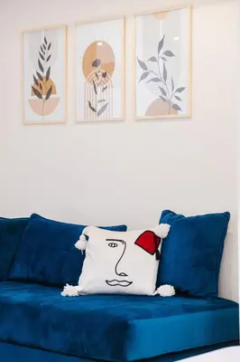 a blue couch with a white pillow on it at Airport RAK 2Br perfect for early & late flights in Marrakech