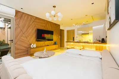 a bedroom with a large white bed and a kitchen at NEW - Central 1BR-Kingsize, AC & Terrace Parking in Marrakech