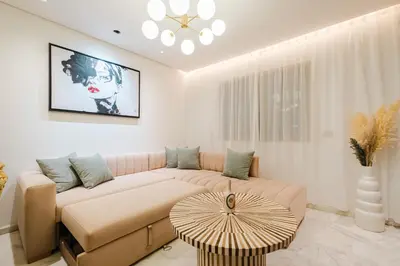 a living room with a couch and a table at NEW - Central 1BR-Kingsize, AC & Terrace Parking in Marrakech