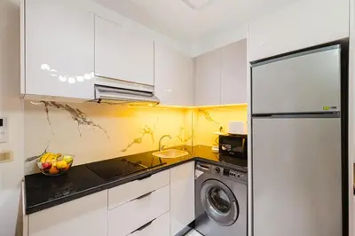 a kitchen with white cabinets and a washer at NEW - Central 1BR-Kingsize, AC & Terrace Parking in Marrakech