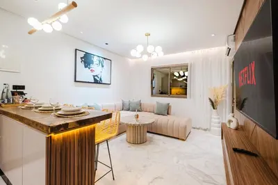 a living room with a couch and a table at NEW - Central 1BR-Kingsize, AC & Terrace Parking in Marrakech