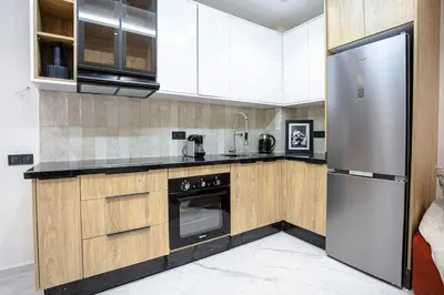 a kitchen with wooden cabinets and a stainless steel refrigerator at The Icon Boutique Hivernage in Marrakech