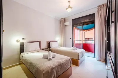two beds in a room with a window at NEW 2Br Family-Friendly, in the Heart of Marrakech in Marrakech