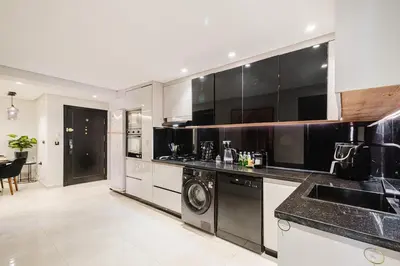 a kitchen with black cabinets and a washer and dryer at NEW 2Br Family-Friendly, in the Heart of Marrakech in Marrakech