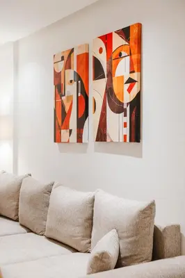 a white couch with three paintings on a wall at NEW Apartment Central 1BR-Queensize, AC&Terrace in Marrakech