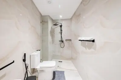 a white bathroom with a toilet and a shower at NEW Apartment Central 1BR-Queensize, AC&Terrace in Marrakech