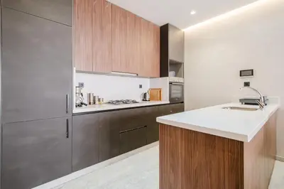 a kitchen with wooden cabinets and a white counter top at Modern Comfort in Heart of Marrakech in Marrakech