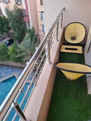 a balcony with two chairs and a table next to a pool at Burj malak in Marrakech