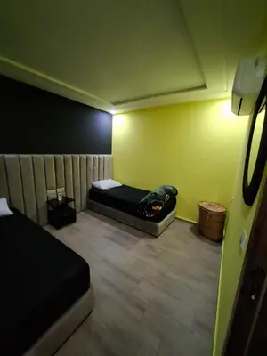 a small room with a bed and a yellow wall at Burj malak in Marrakech