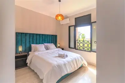 a bedroom with a large bed with a green headboard at Luxury private villa with heated pool in Marrakech