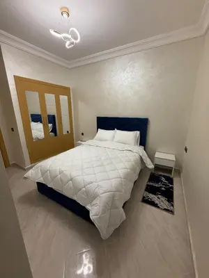 a bedroom with a large bed with a white comforter at Moroccan elegance Quiet & Comfort 5min airport in Marrakech